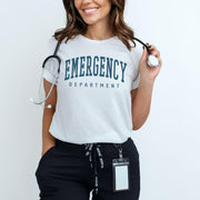 Person wearing a white 'EMERGENCY DEPARTMENT' t-shirt holding a stethoscope.