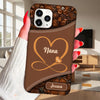 Brown phone case with floral design and 'Nana Jessica' text held by a hand.
