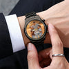 Person wearing a black wristwatch with a personalized photo display on the watch face.
