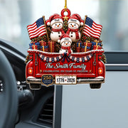 Personalized Christmas ornament shaped like the back of a red pickup truck carrying three snowmen, wrapped gifts, and American flags, hanging in a car.