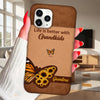 Phone case with butterfly design and text 'Life is better with Grandkids' held by a person.